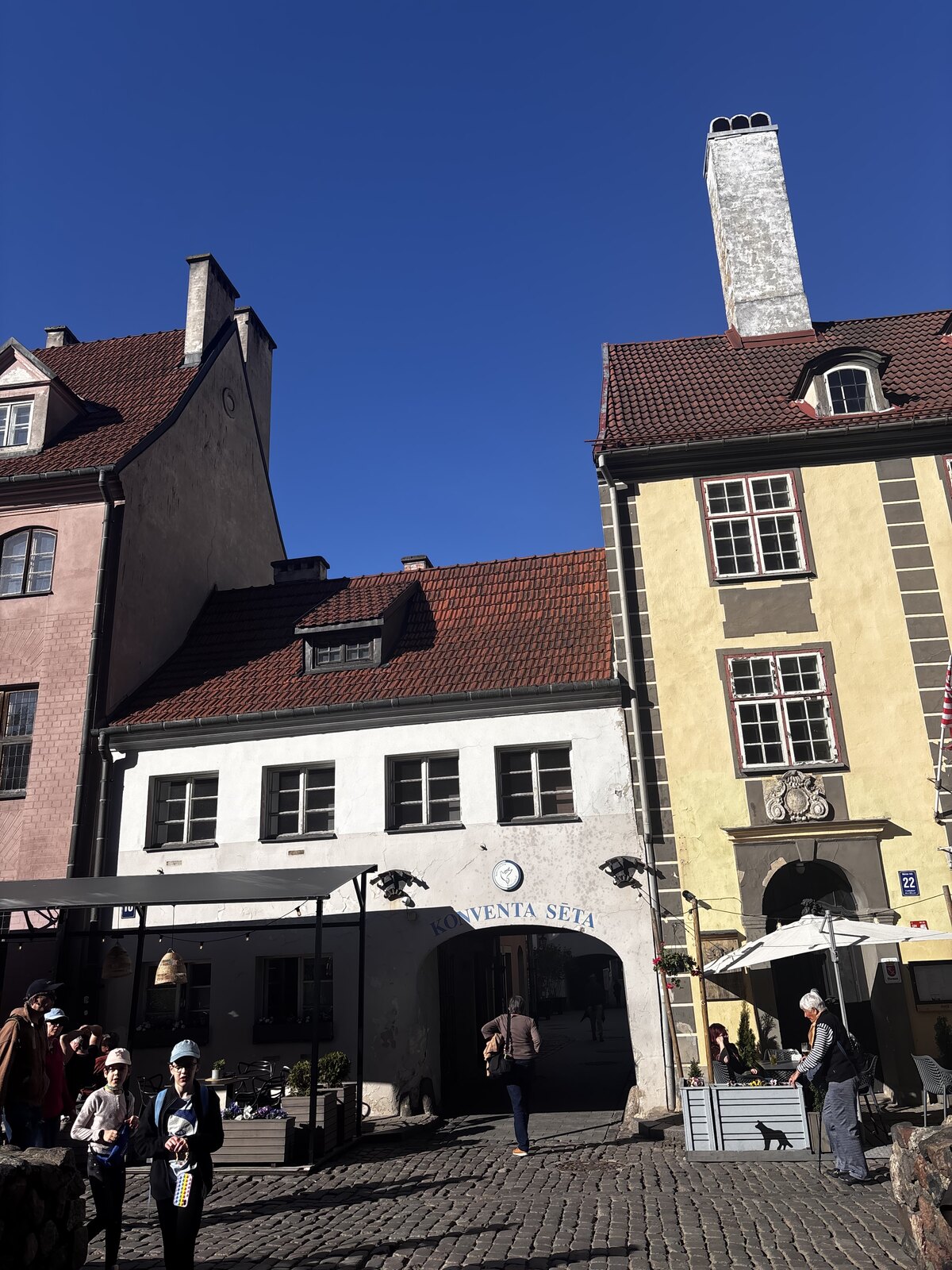 A entrada em arco da Konventa Sēta a partir da Kalēju iela na cidade velha de Riga, Letónia, com a placa «KONVENTA SĒTA» por cima do arco.