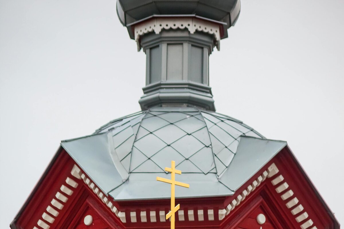 Uma igreja ortodoxa de madeira com cúpula em forma de cebola e a cruz ortodoxa de oito pontas e três barras, Letónia.