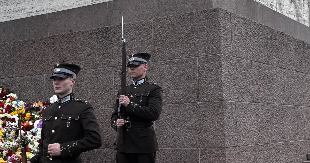 Guarda de honra do Exército letão no Monumento à Liberdade com uma parede de flores depositada junto à base, Riga, no Dia da Restauração da Independência