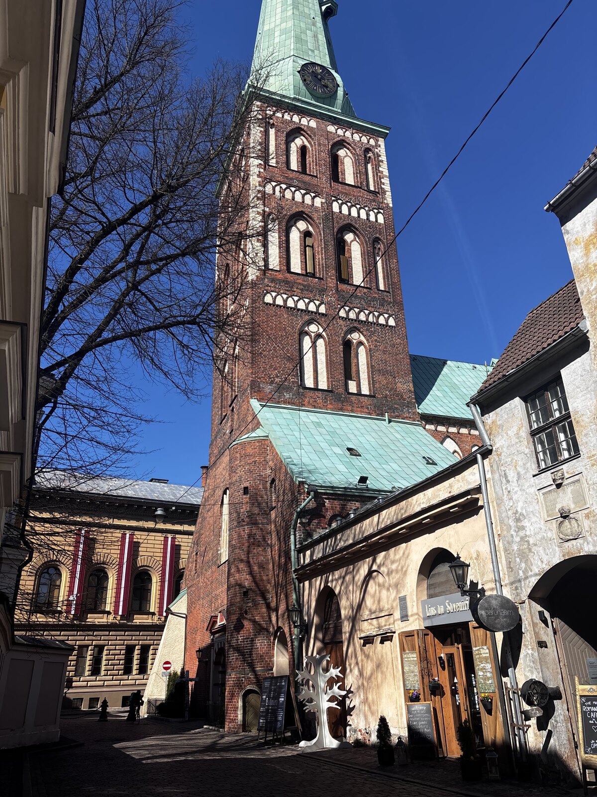 Catedral de São Tiago (Sv. Jēkaba katedrāle) na Jēkaba iela, na Cidade Velha de Riga, Letónia, com uma torre gótica alta e esguia sobre um corpo de tijolo.