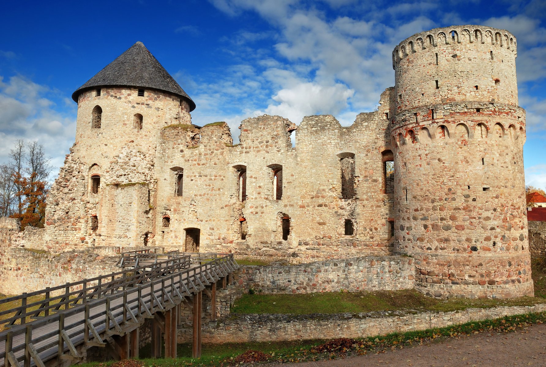 Exterior das ruínas do castelo medieval de Cēsis, paredes de tijolo vermelho na luz de outono, Letónia