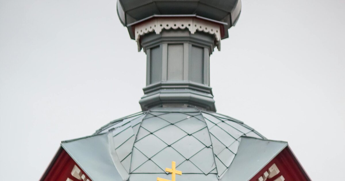 Uma igreja ortodoxa de madeira com cúpula em bolbo e a cruz ortodoxa de oito pontas e três barras, Letónia.