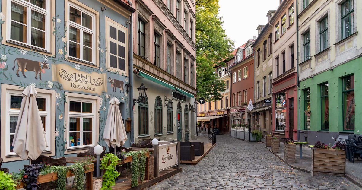 Rua de calçada com restaurantes na Cidade Velha de Riga, Letónia.