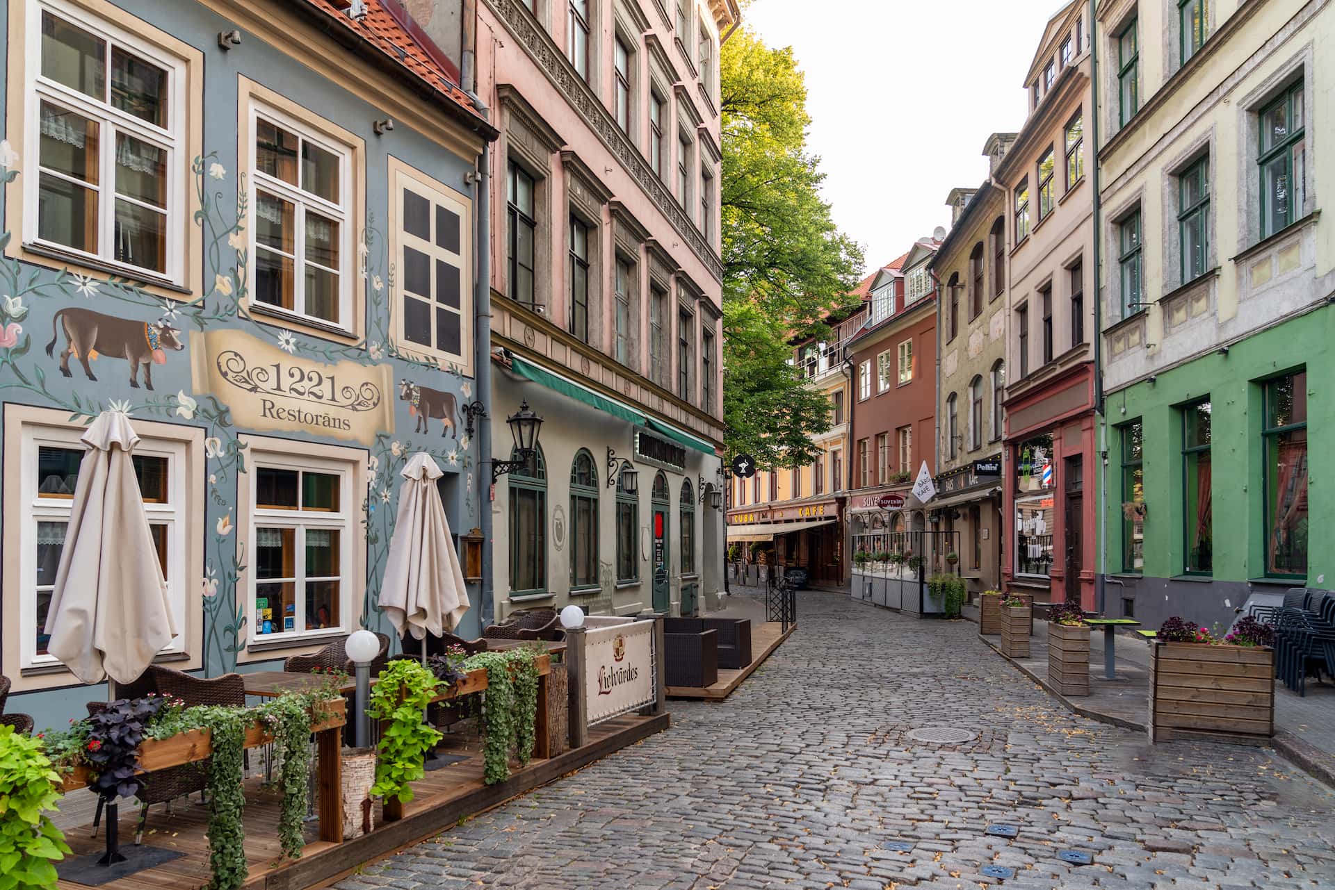 Rua estreita de calçada na Cidade Velha de Riga com fachadas hanseáticas restauradas